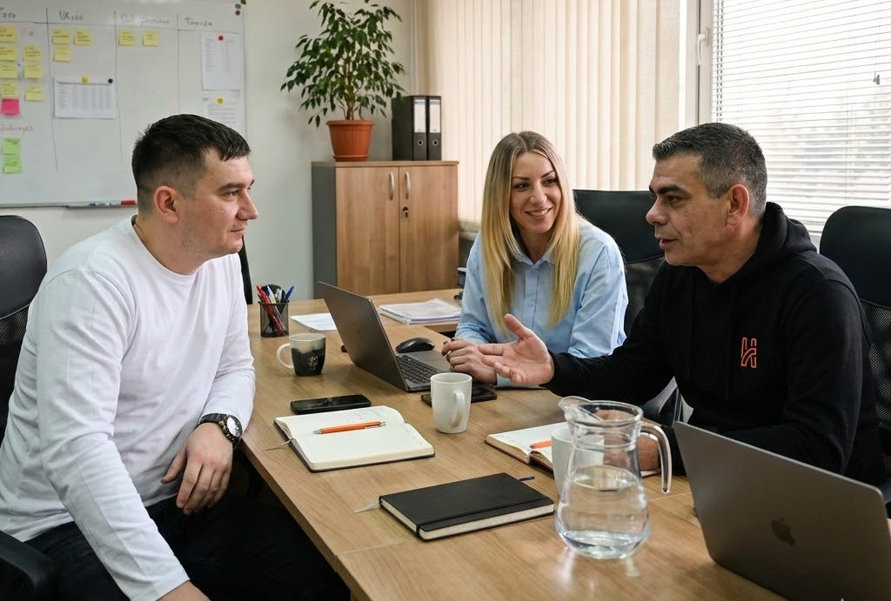 Three Humble Logistics team members talking at a desk in the office